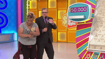 Drew dancing with a contestant next to the plinko board