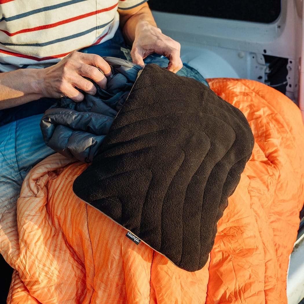 model stuffing a travel pillowcase with a jacket