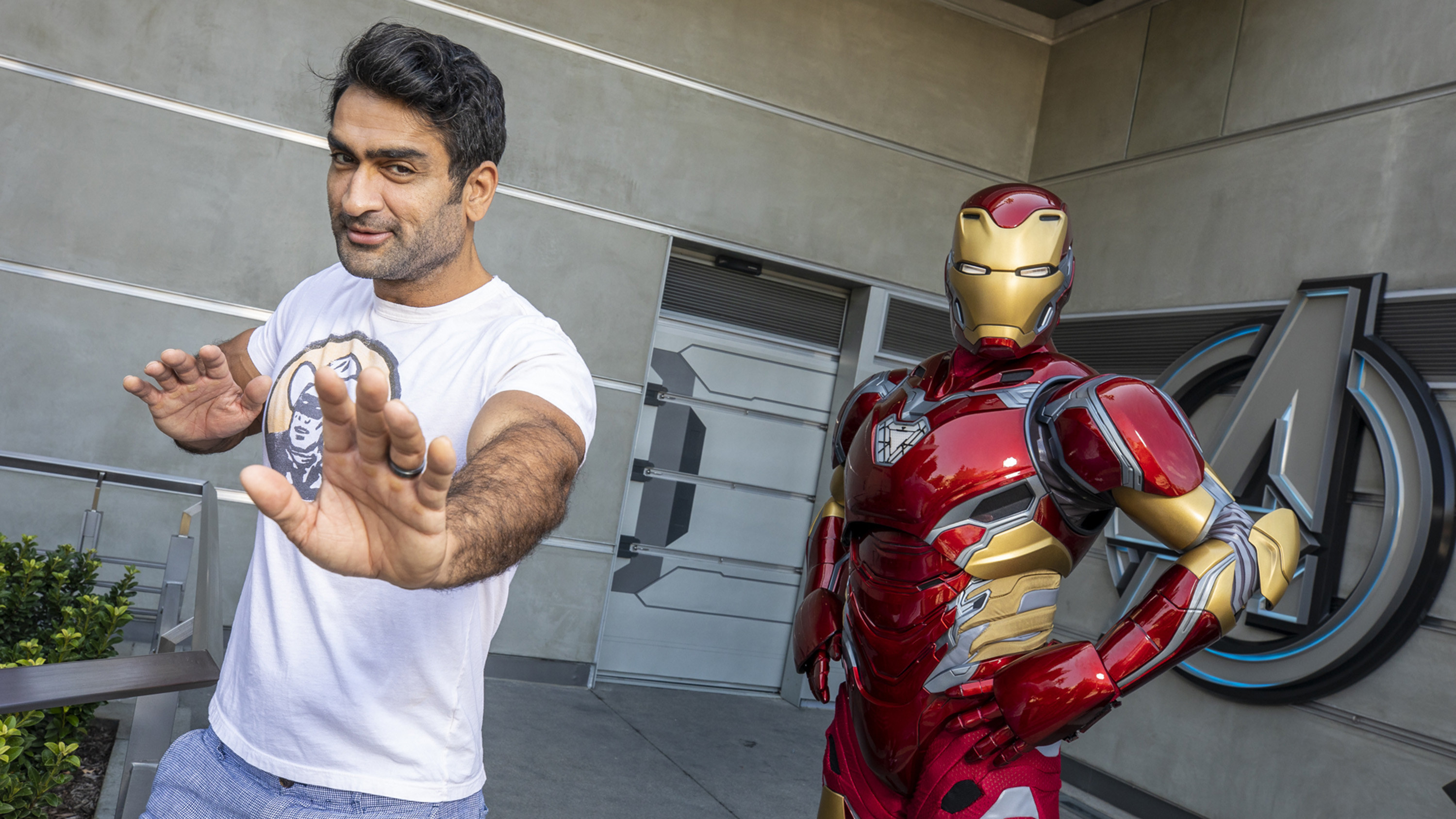 Kumail Nanjiani posing with a statue of Iron Man