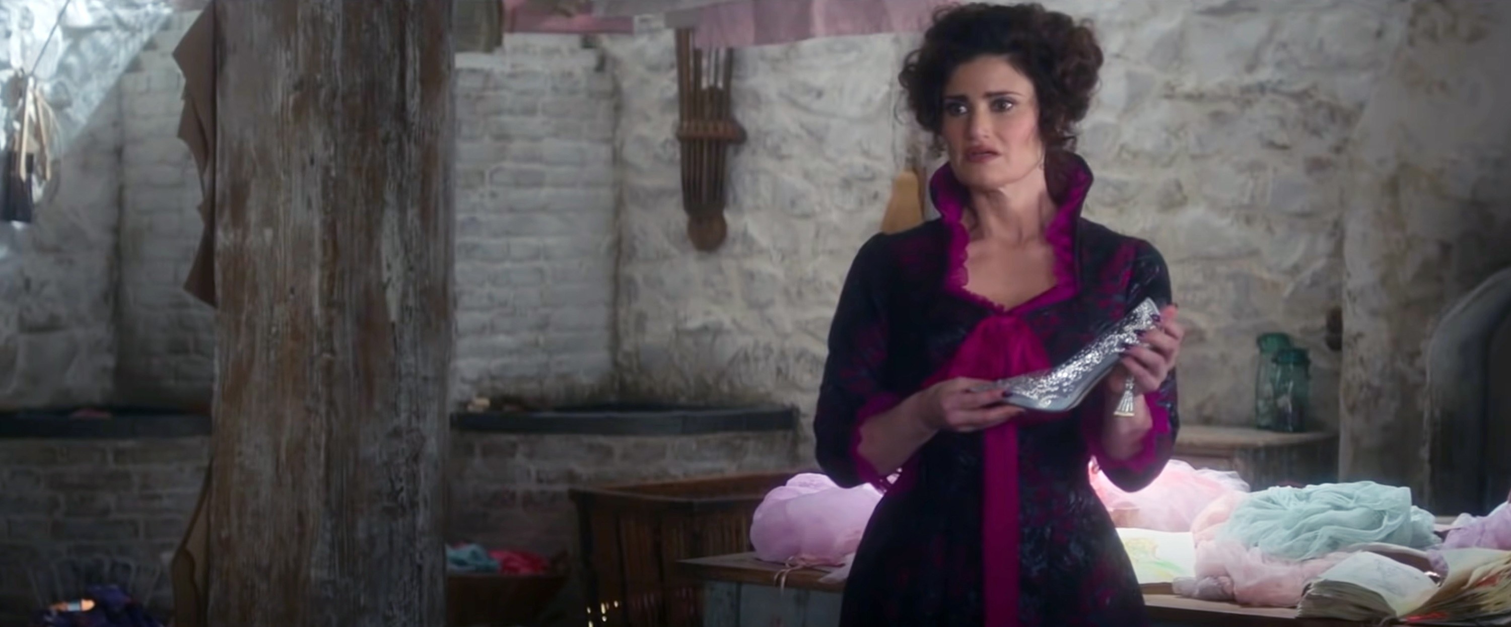 Idina as the stepmother, singing while holding the glass slipper and looking sad
