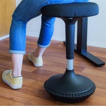 closeup of person half standing and using the wobble stool to balance