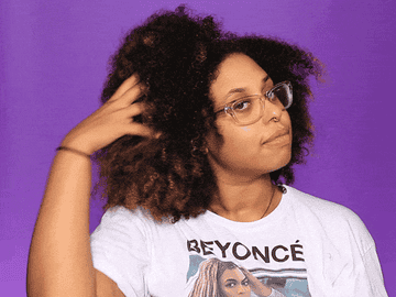 A gif of a woman running her fingers through her natural curls
