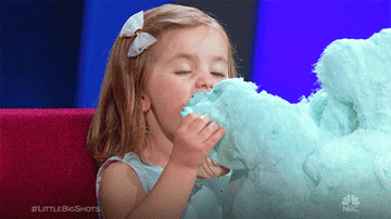 A little girl eating cotton candy