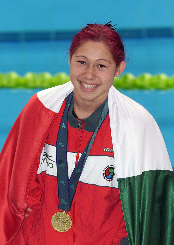 mujer con bandera de México y medalla de oro