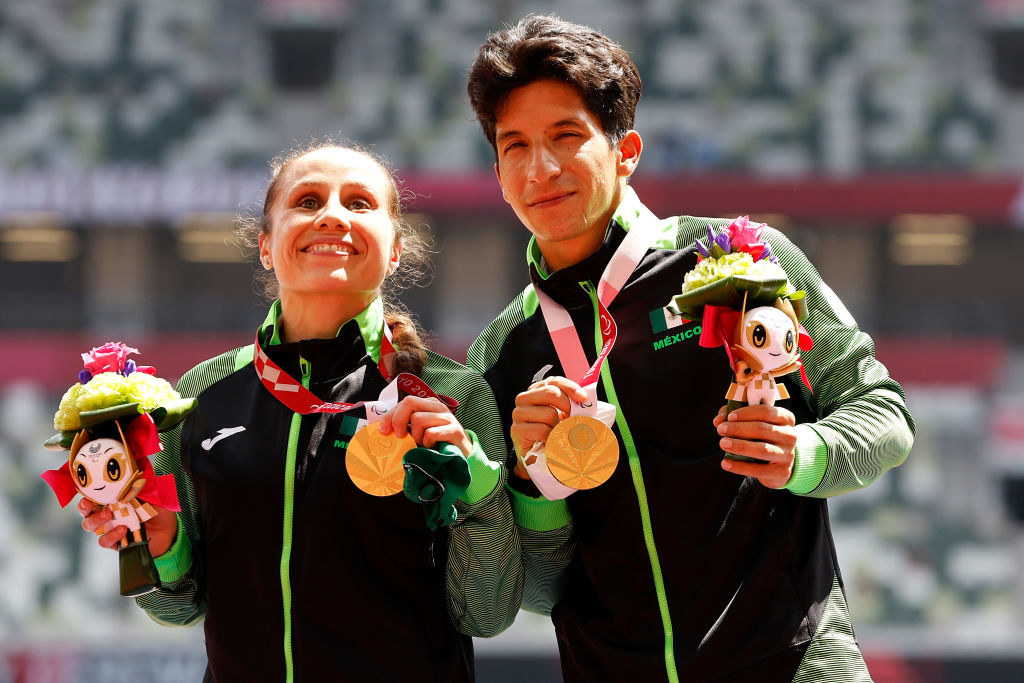 mujer y hombre mostrando medallas de oro