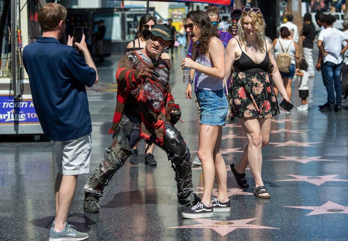 People interacting with a guy dressed as Freddy Kreuger on Hollywood Boulevard