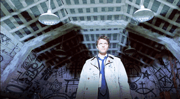 Castiel standing in the barn with wings appearing behind him
