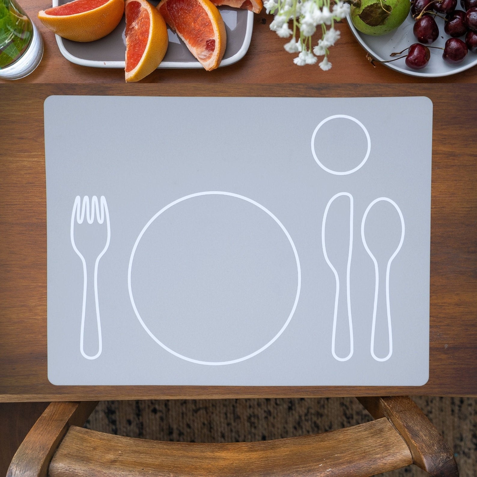 The grey silicone mat with marking to guide children to set the table