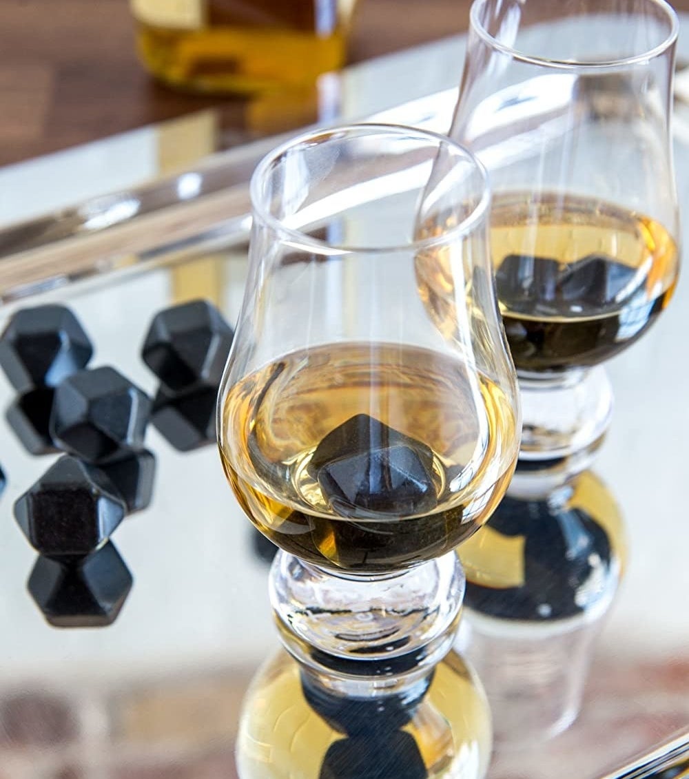 Two glasses with whisky and stones in them