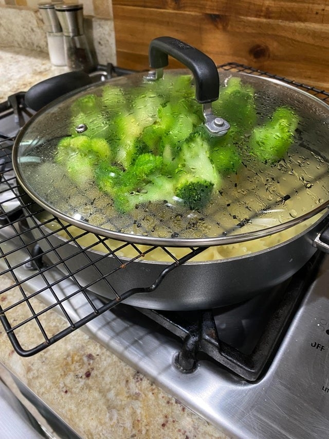 Broccoli steaming over a pot of pasta