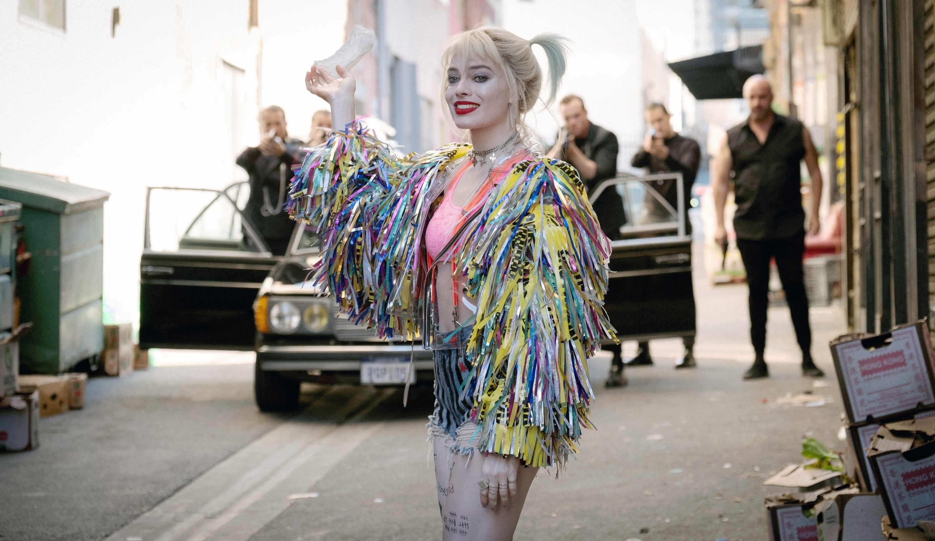Harley in her suspenders, bright velvet crop tank, and american flag jean shorts from other outfits mentioned, but this time with a thick fringed jacket with lots of shiny confetti pieces and caution tape shredded
