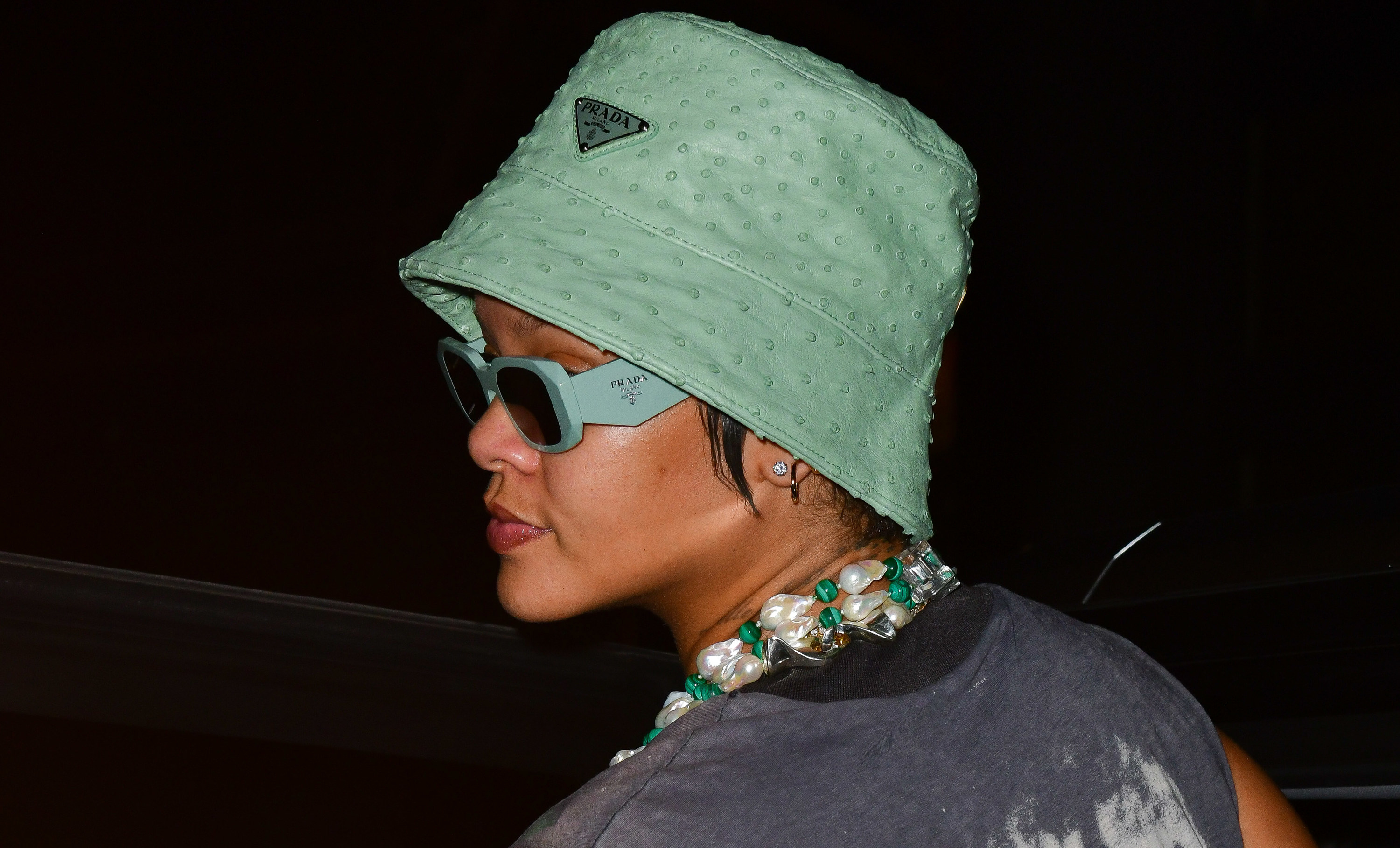 Rihanna is photographed wearing a green hat and sunglasses in New York City