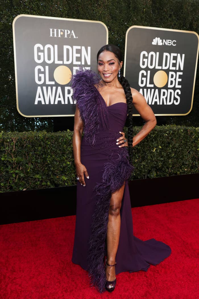 Angela in a one-shoulder gown and thigh-long braid poses on the Golden Globes red carpet