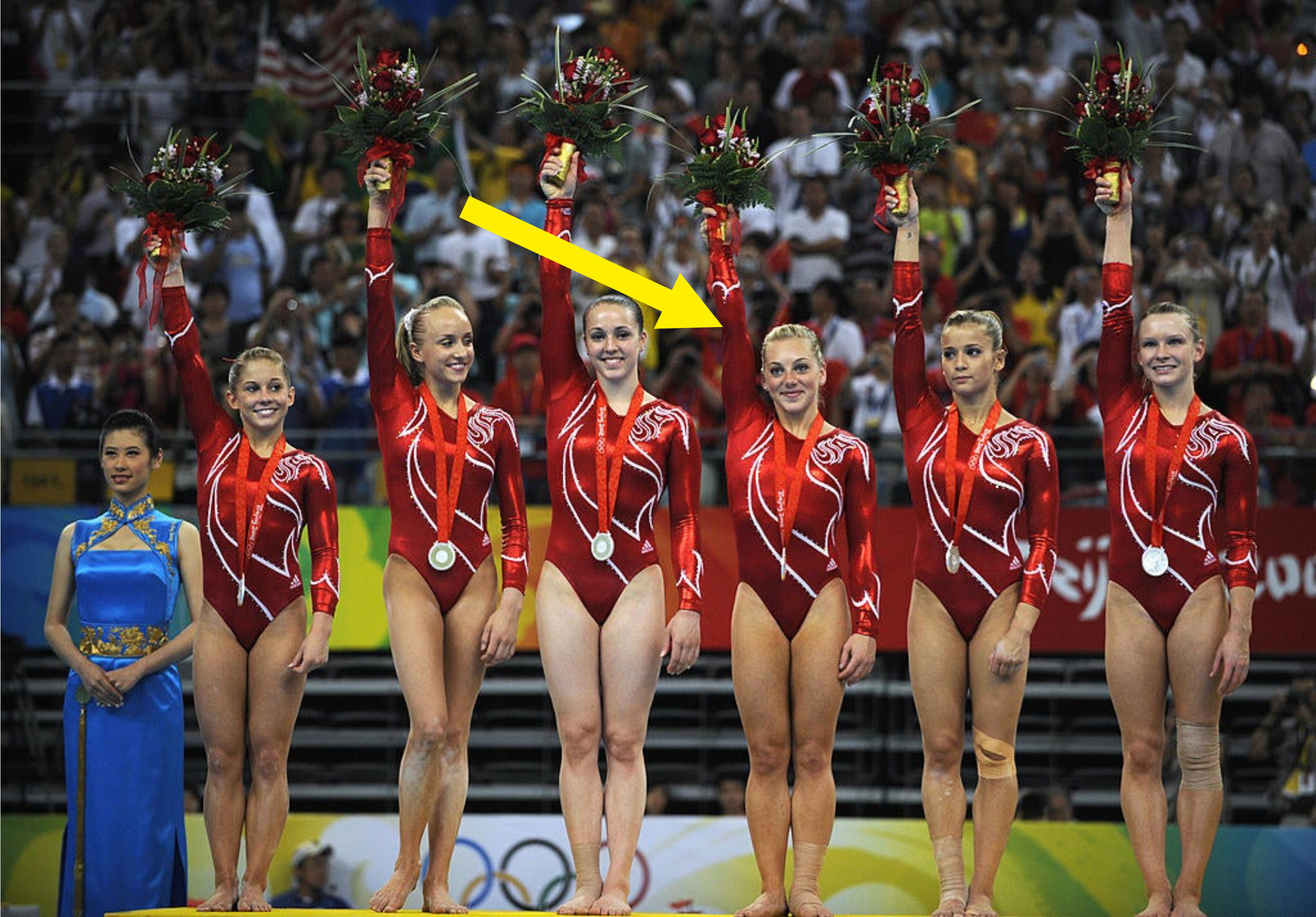 Samantha saluting spectators alongside her teammates during the medal ceremony