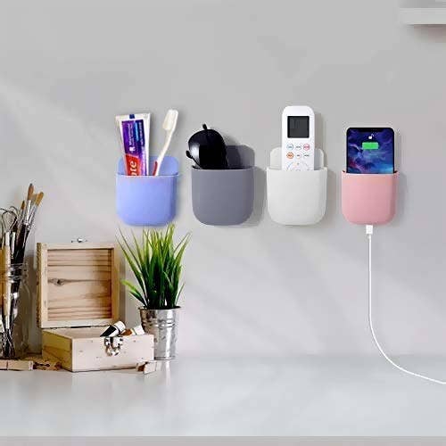 4 wall mount storage cases in different colours holding a remote, sunglasses, a charging phone and a toothbrush and toothpaste