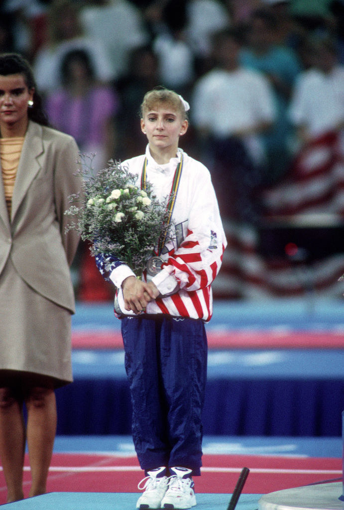 Shannon standing on the platform with her bouquet of flowers during the medal ceremony