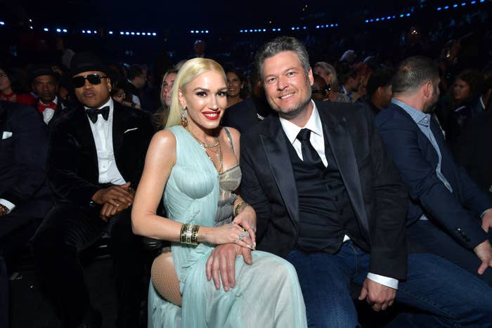 Gwen, in a gown, and Blake, in a suit smiling for the camera at an awards show with LL Cool J in the background