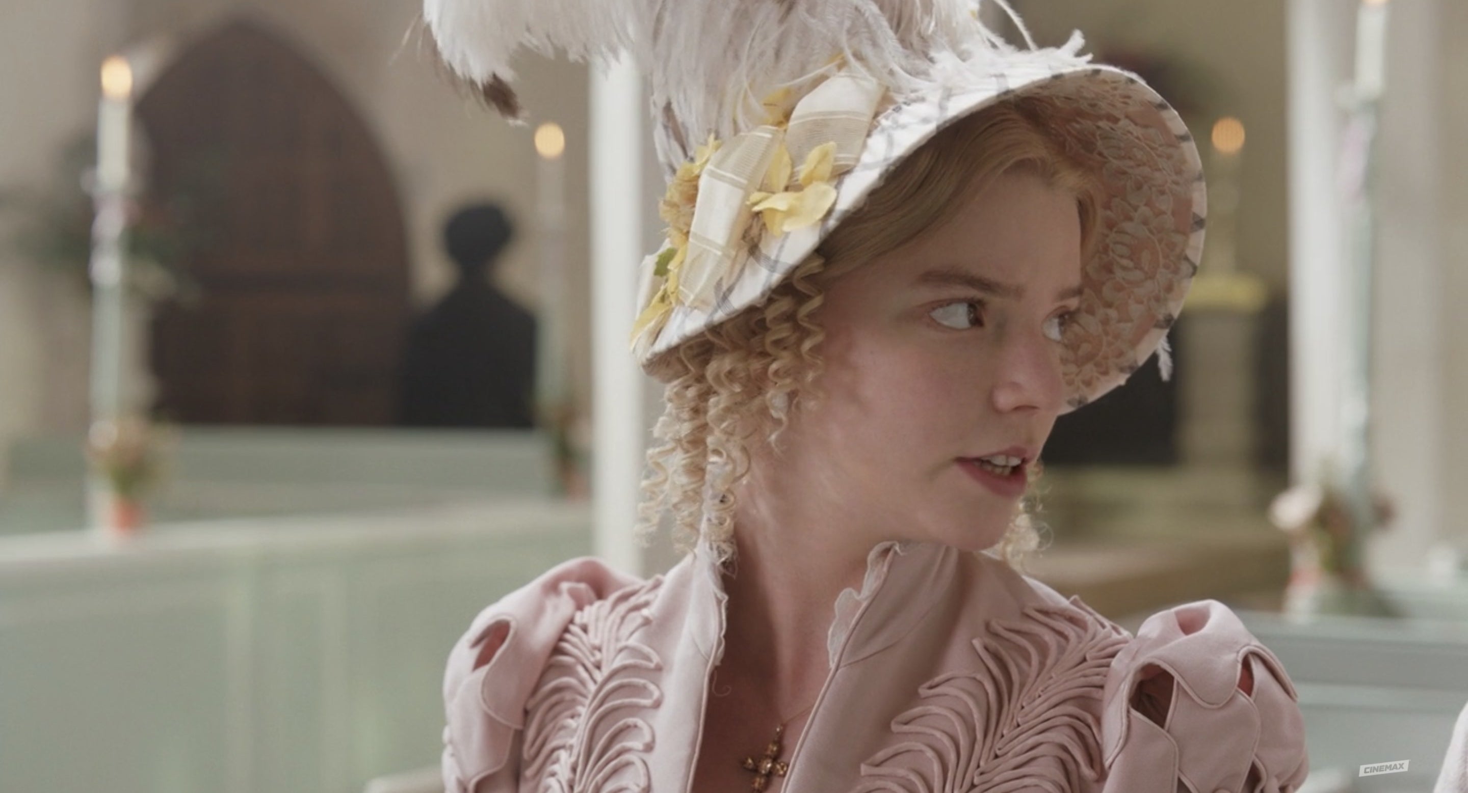 Emma wears an embellished hat complete with feathers and ribbons.