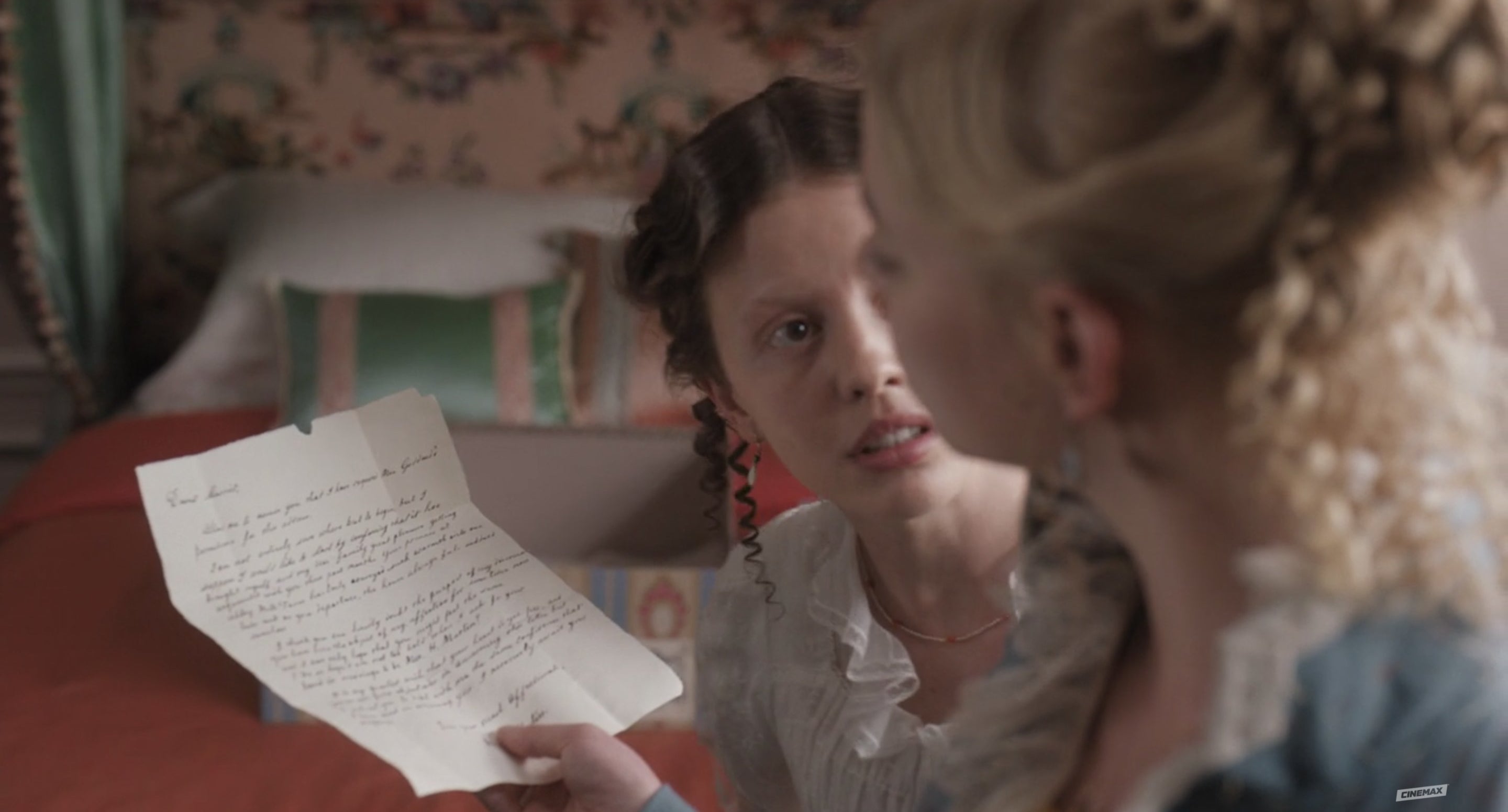 Emma reads a letter with Harriet beside her