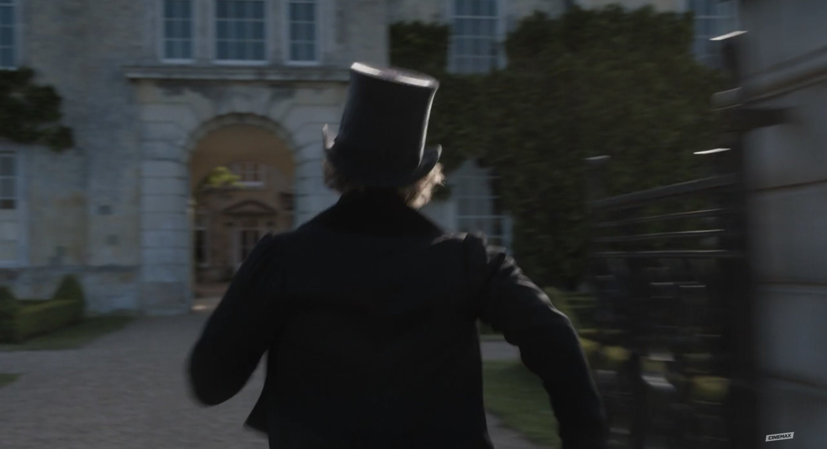 Knightley in a top hat running, we see him from behind