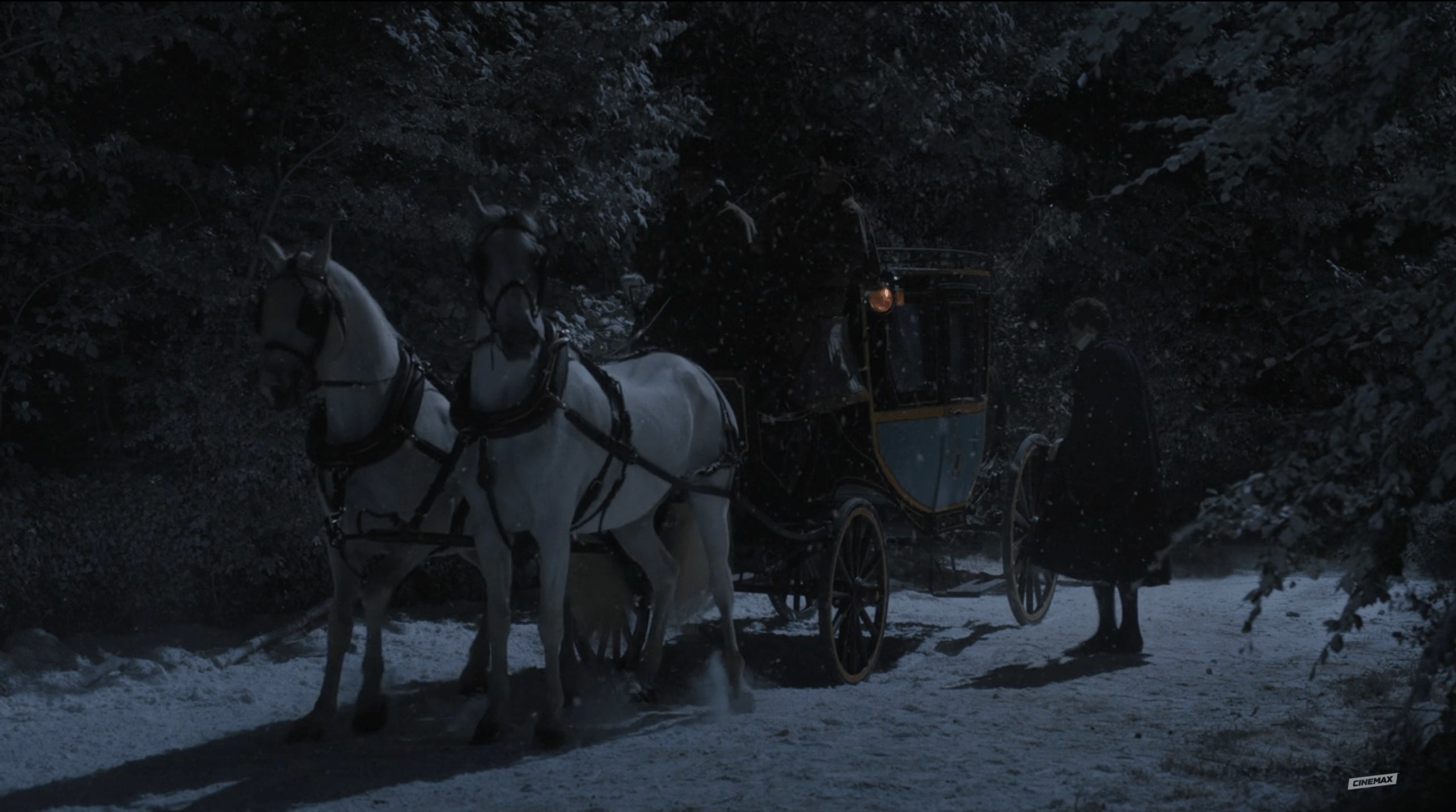 A carriage drawn by two horses sits in the snow