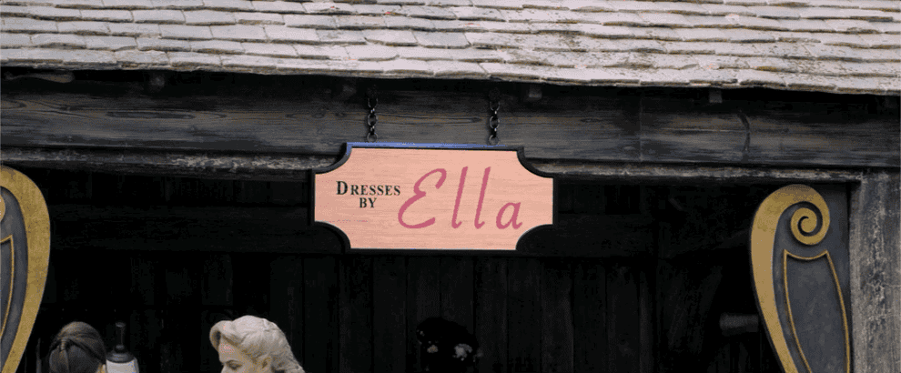 Ella admires her Dresses by Ella storefront sign