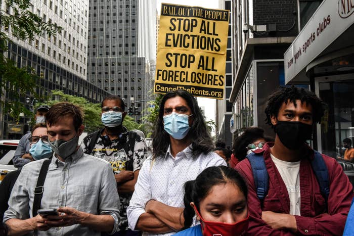 Protestors in New York with a sign that says stop all evictions, stop all foreclosures