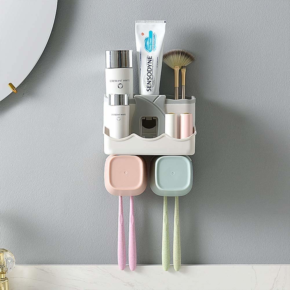 An Adhesive bathroom rack with space for storage, two cups, 4 hooks for toothbrushes and a toothpaste dispenser