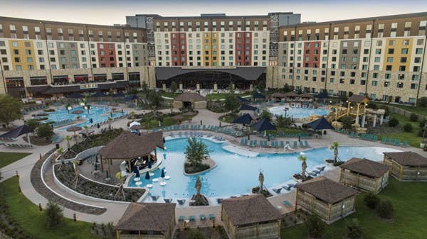 An aerial view of swimming pools lined with deck chairs at a resort