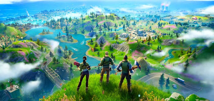 Three Fortnite characters standing on top of a hill overlooking the rest of the Battle Royale area