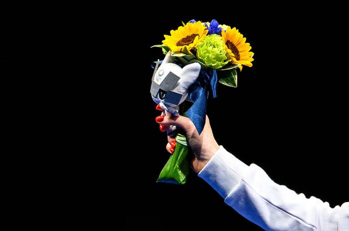 Silver medalist Inna Deriglazova of Team ROC poses with flowers in her hand on the podium