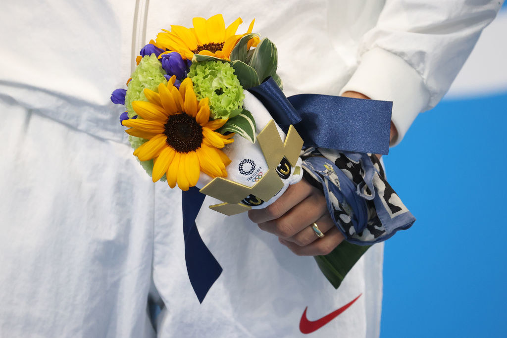 An Olympic athlete holding Tokyo's flower bouquet