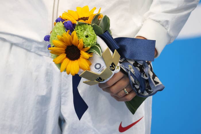 An Olympic athlete holding Tokyo&#x27;s flower bouquet