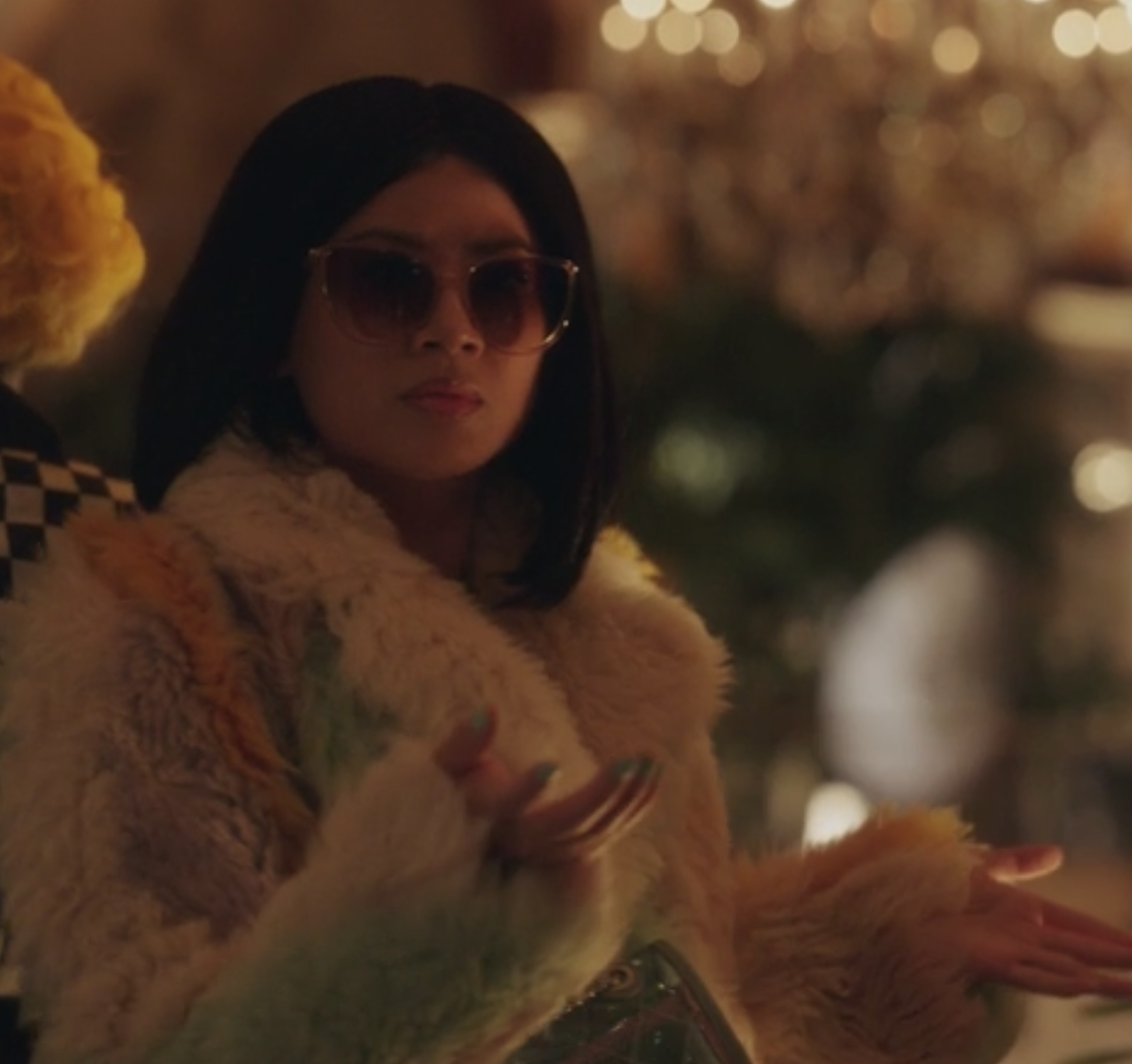 Nelly Yuki wears a colorful fuzzy jacket with dark sunglasses