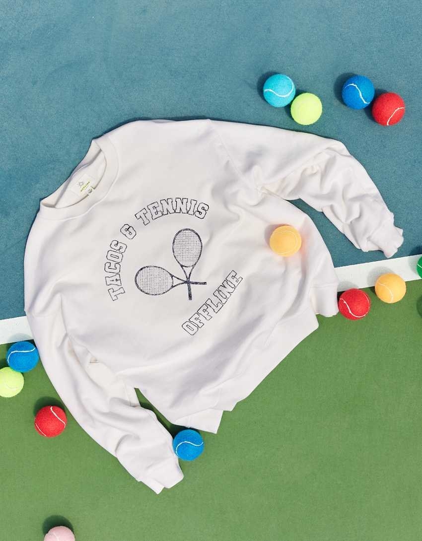 white crewneck sweatshirt with two tennis rackets on it and the words &quot;tacos and tennis offline&quot;