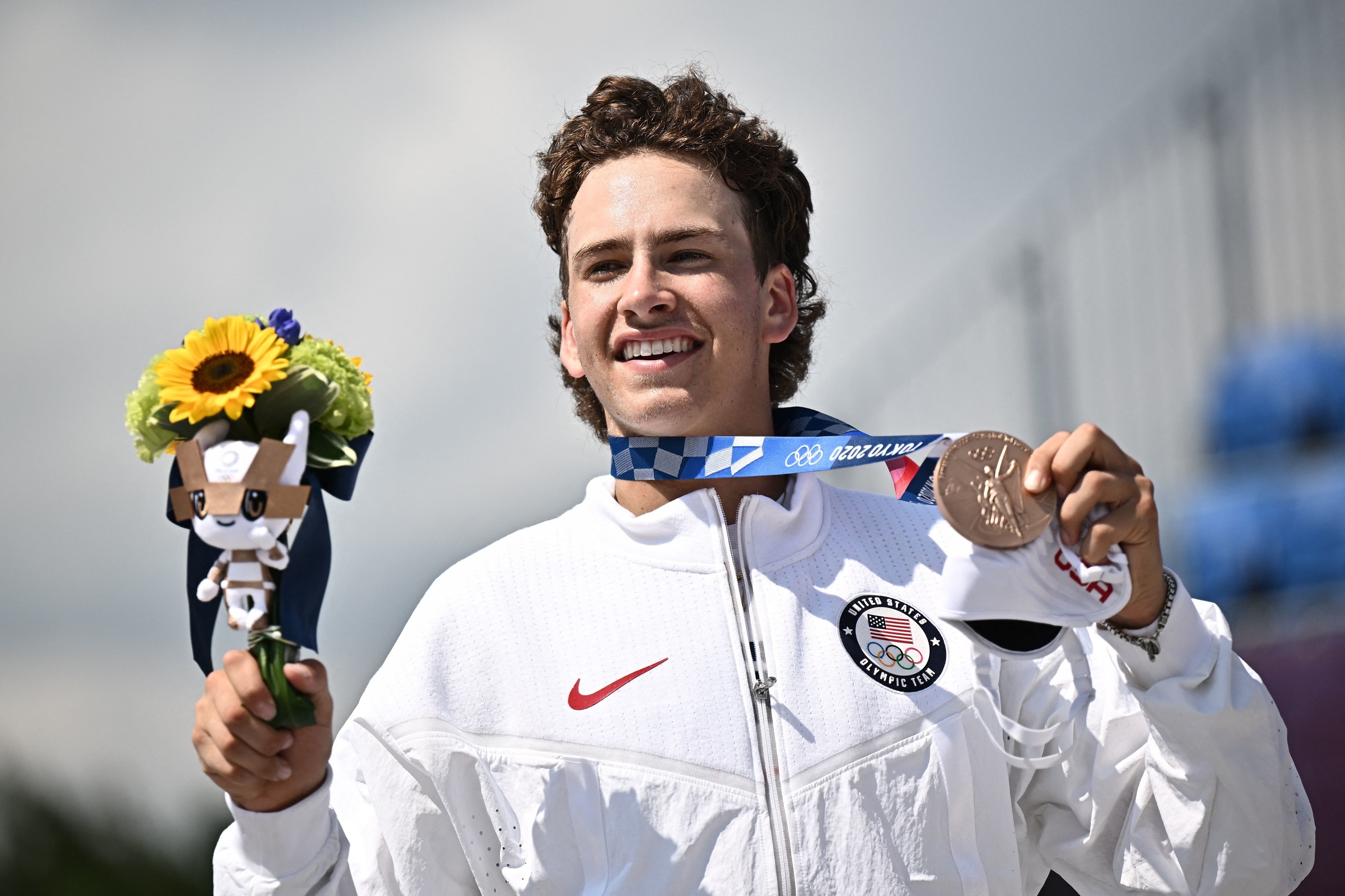 Eaton posing on the podium with his medal and flowers after the men&#x27;s street prelims