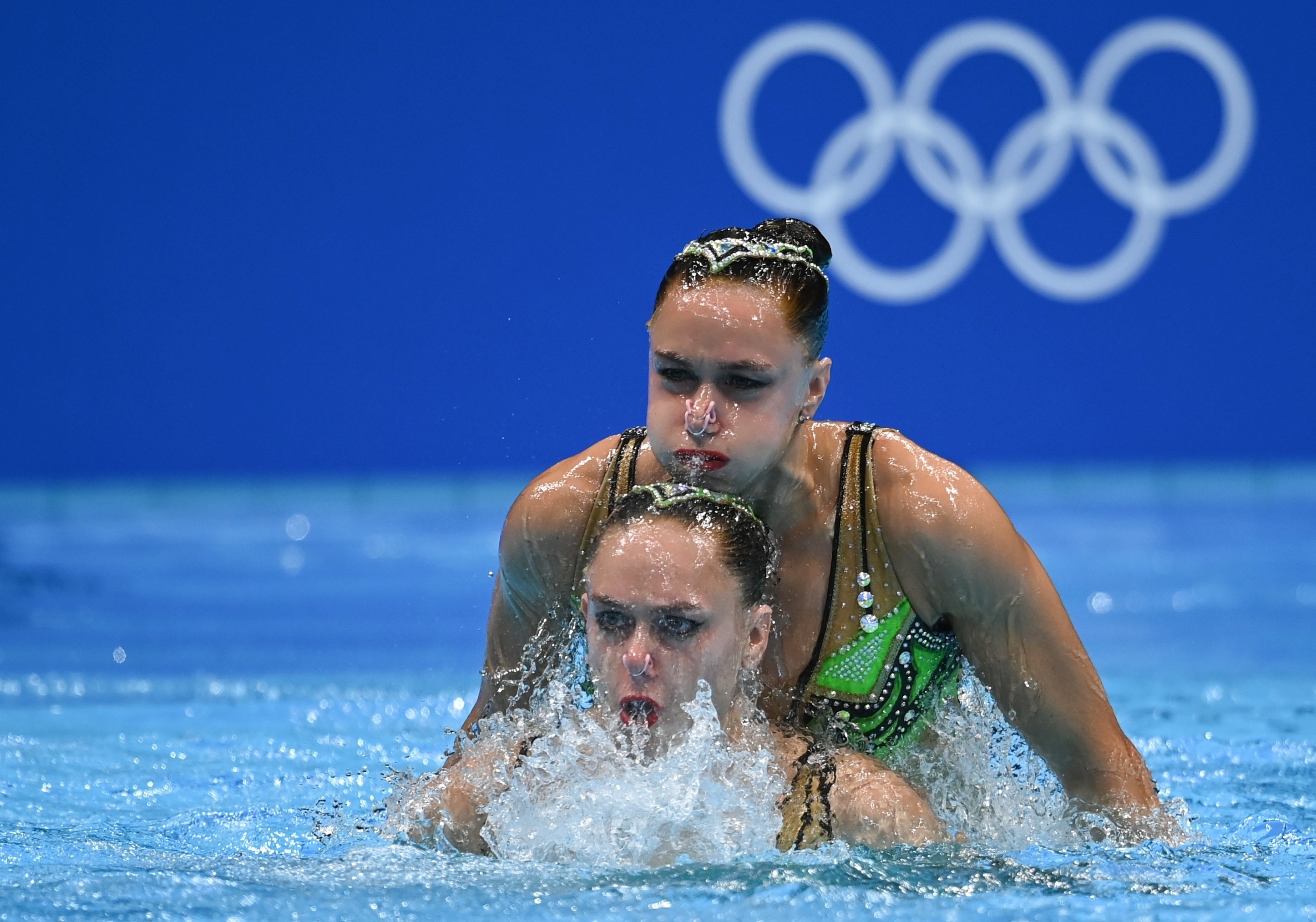 Two women swimmers perform in the pool at the Tokyo Olympics