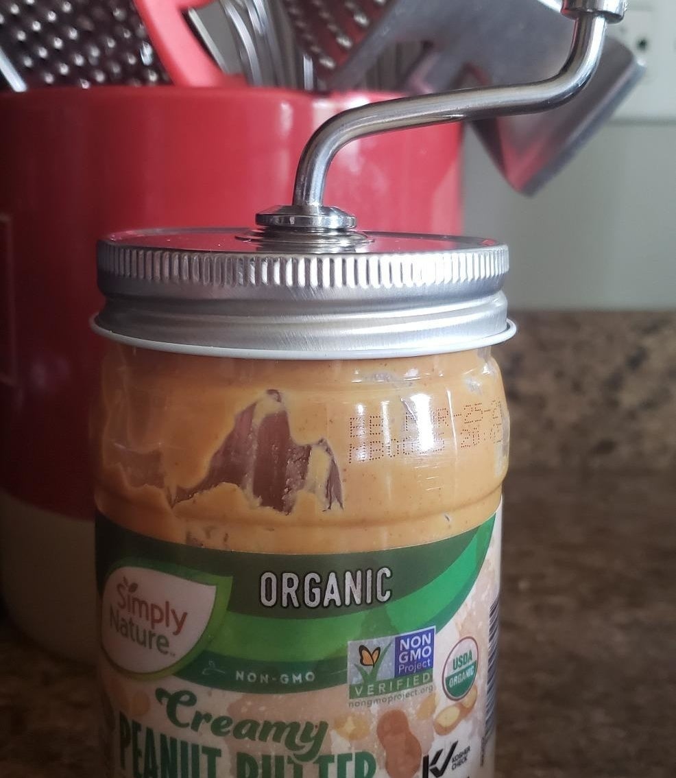 a reviewer photo of the peanut butter mixer on a jar of peanut butter