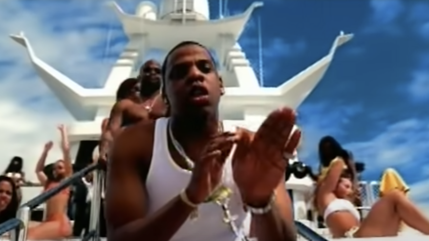 Jay-Z rapping on a boat with girls in bikinis around him