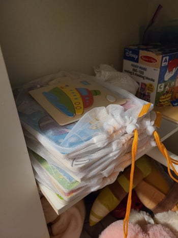 Reviewer's photo showing various puzzles stored in the mesh bags and stacked up on a shelf