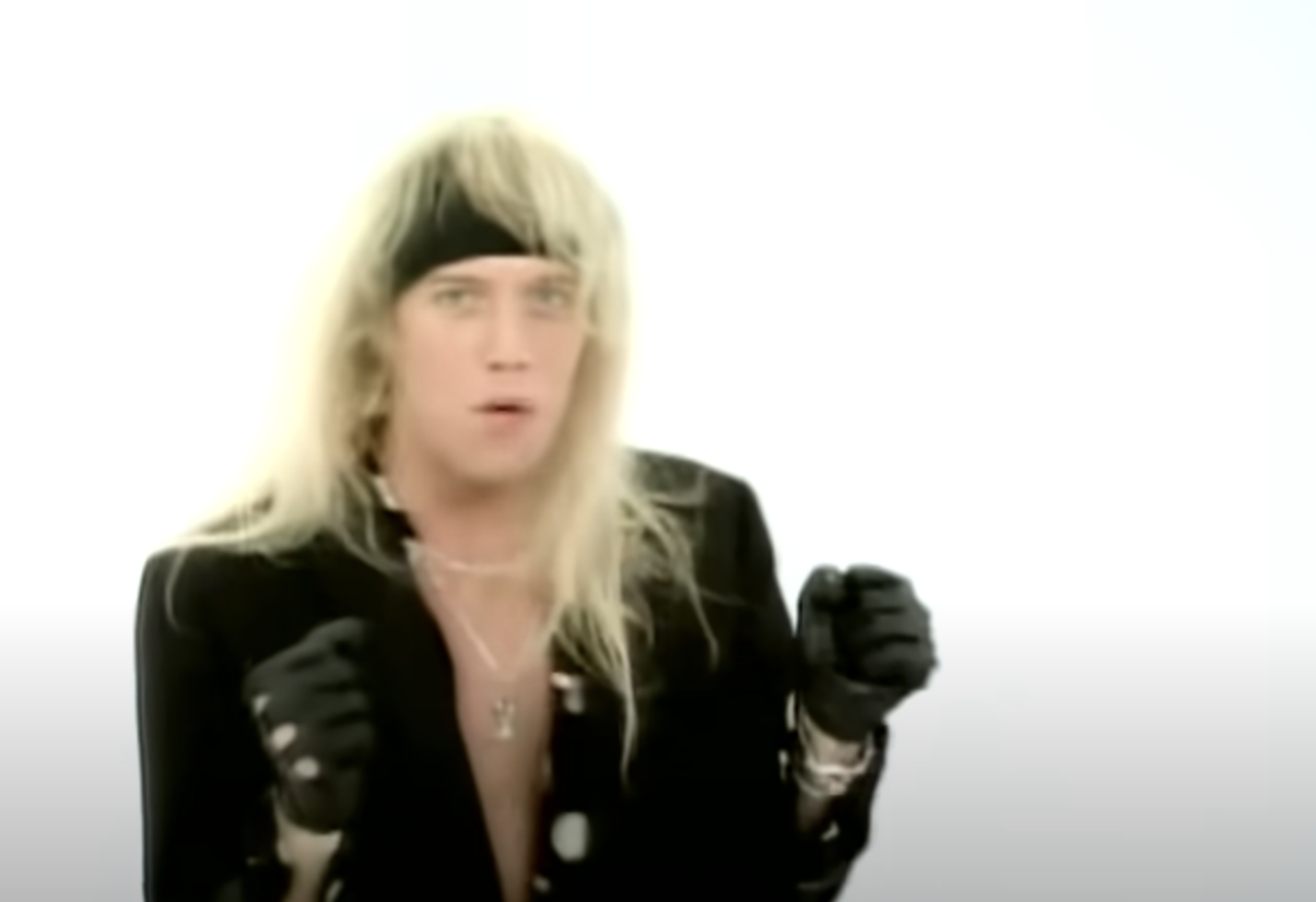 Jani in the music video against a blank backdrop