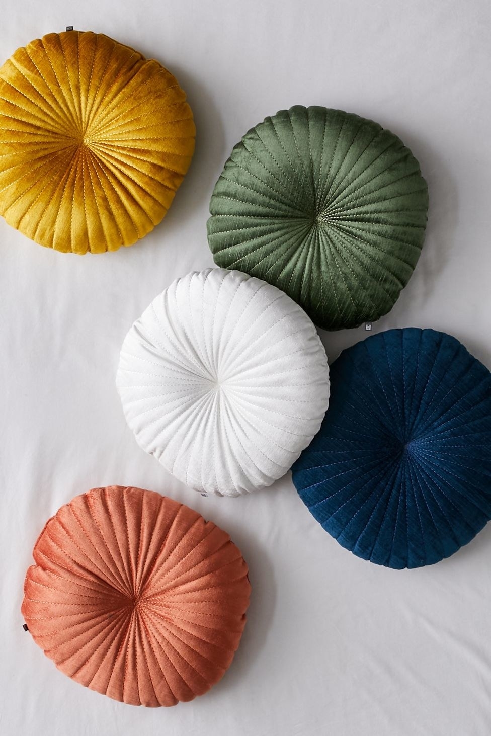 round tufted pillows in white, orange, yellow, green, and blue