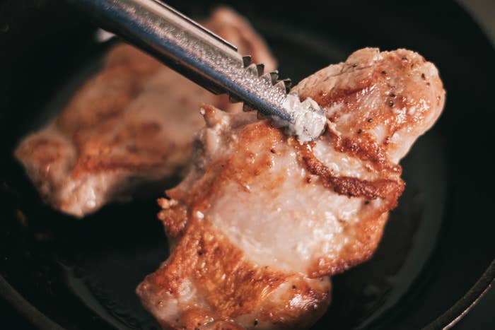 Cooking chicken breasts in a cast iron skillet.