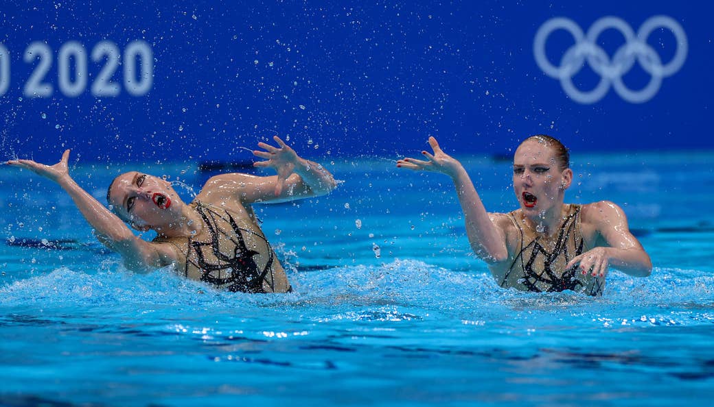 Two women swimmers perform in the pool at the Tokyo Olympics