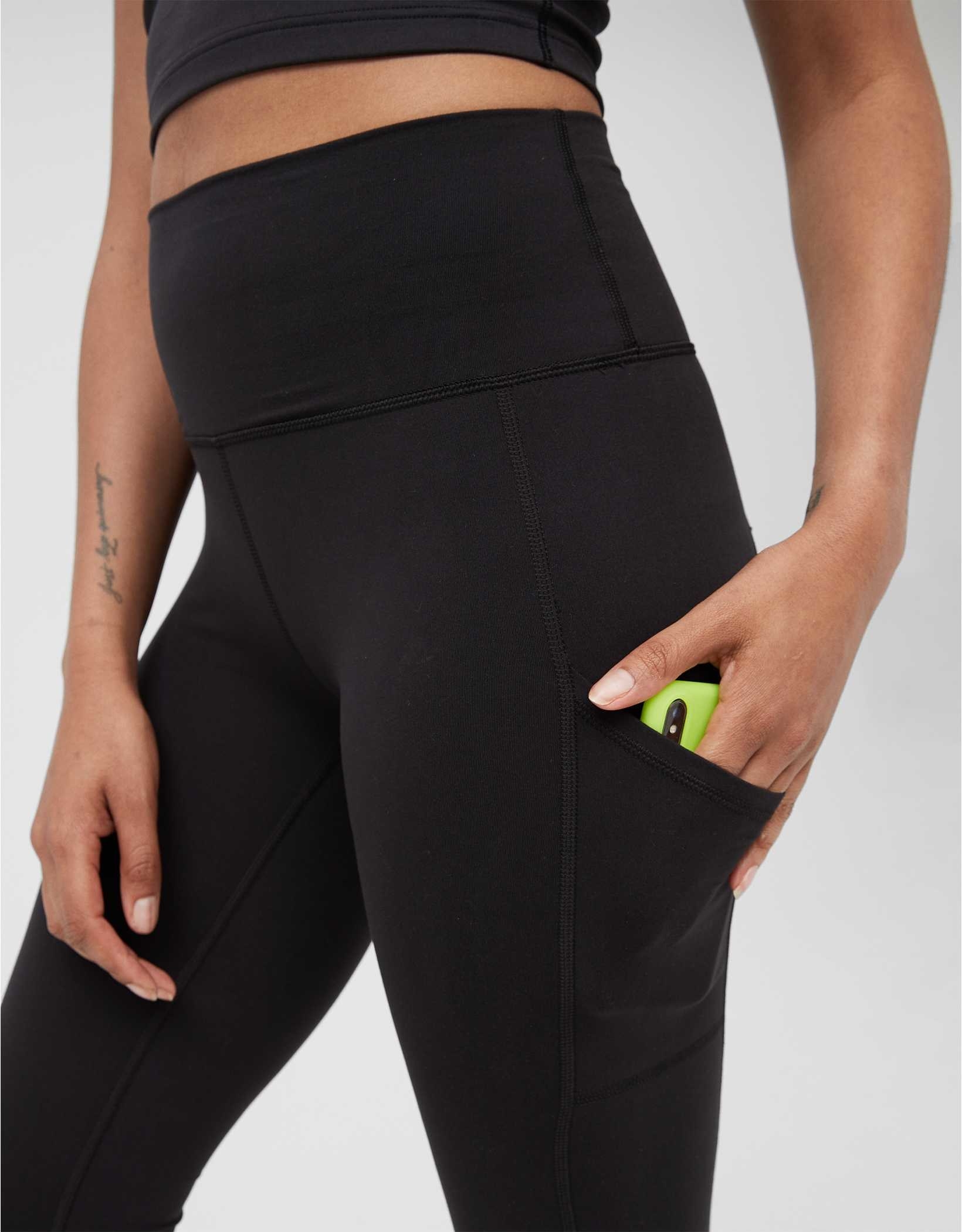 model putting cellphone into thigh pocket on the leggings