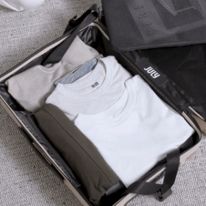 gif of hands packing the suitcase and using the strap to tighten it