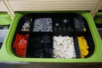 A storage bin within an Ikea Trofast bin with compartments containing legos sorted by color
