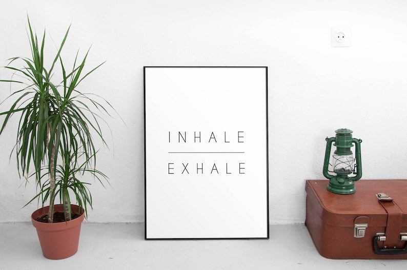 a white wall art print in a black frame. The print says &quot;inhale exhale&quot; with a horizontal line in between both words. Yes baby. Minimalist wall art for the win.