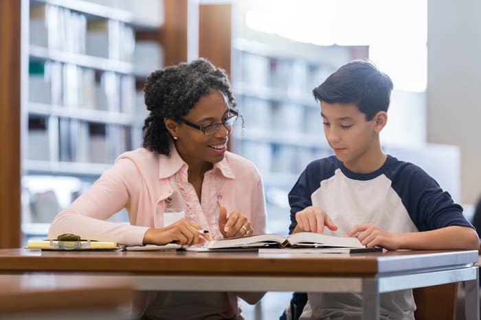 Teacher working with a student in a library