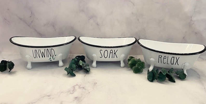 three mini ceramic bathtubs the size of small baskets. They respectively say &quot;unwind, soak, and relax&quot;